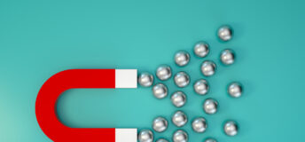 A large magnet attracting several metal balls